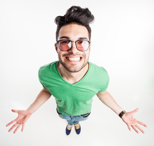 funny handsome man with hipster glasses showing his palms and smiling large  - wide angle shot